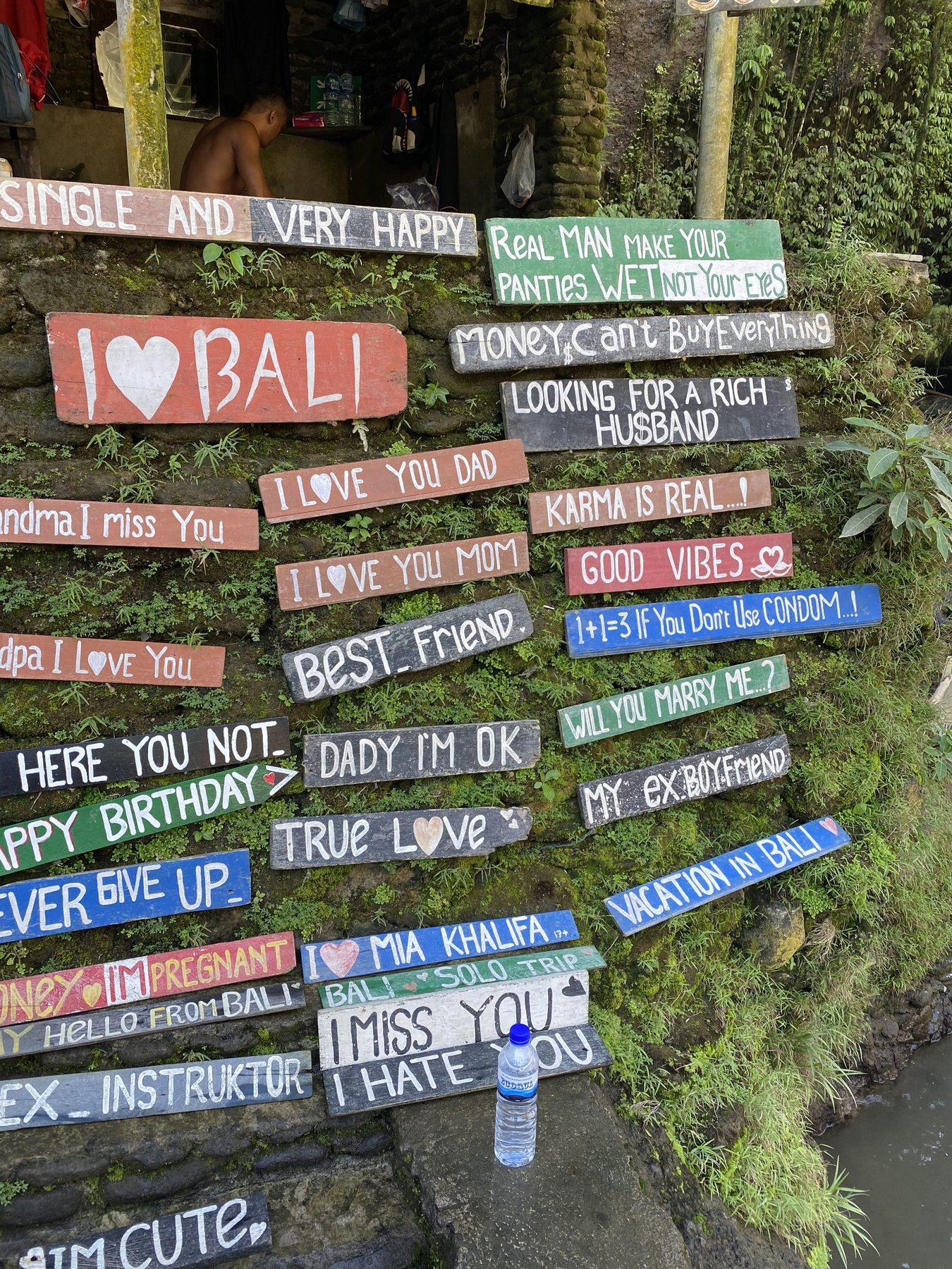 Hand-painted I love Bali signs beside a jungle path