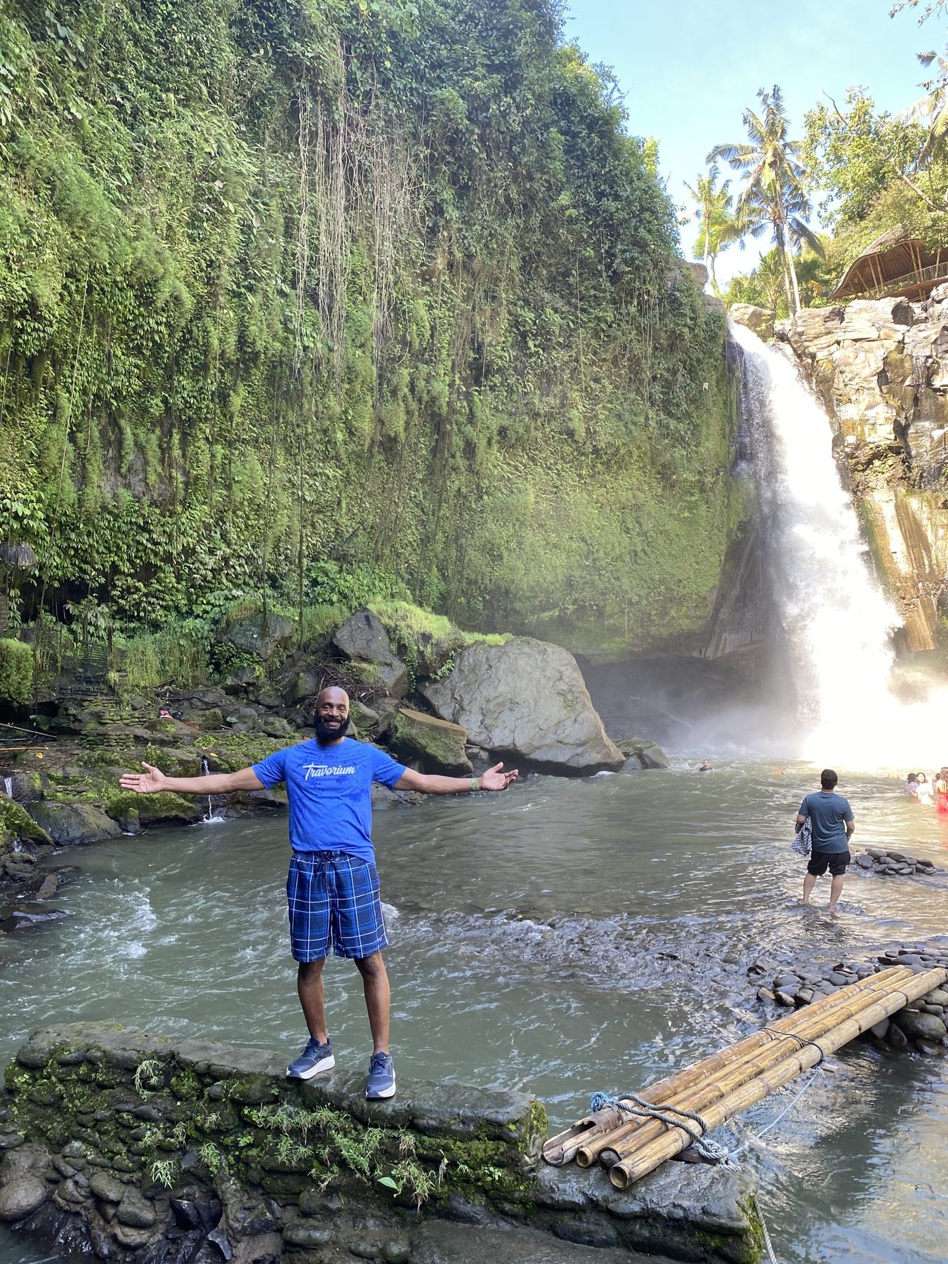 Darnell standing in front of a Bali waterfall